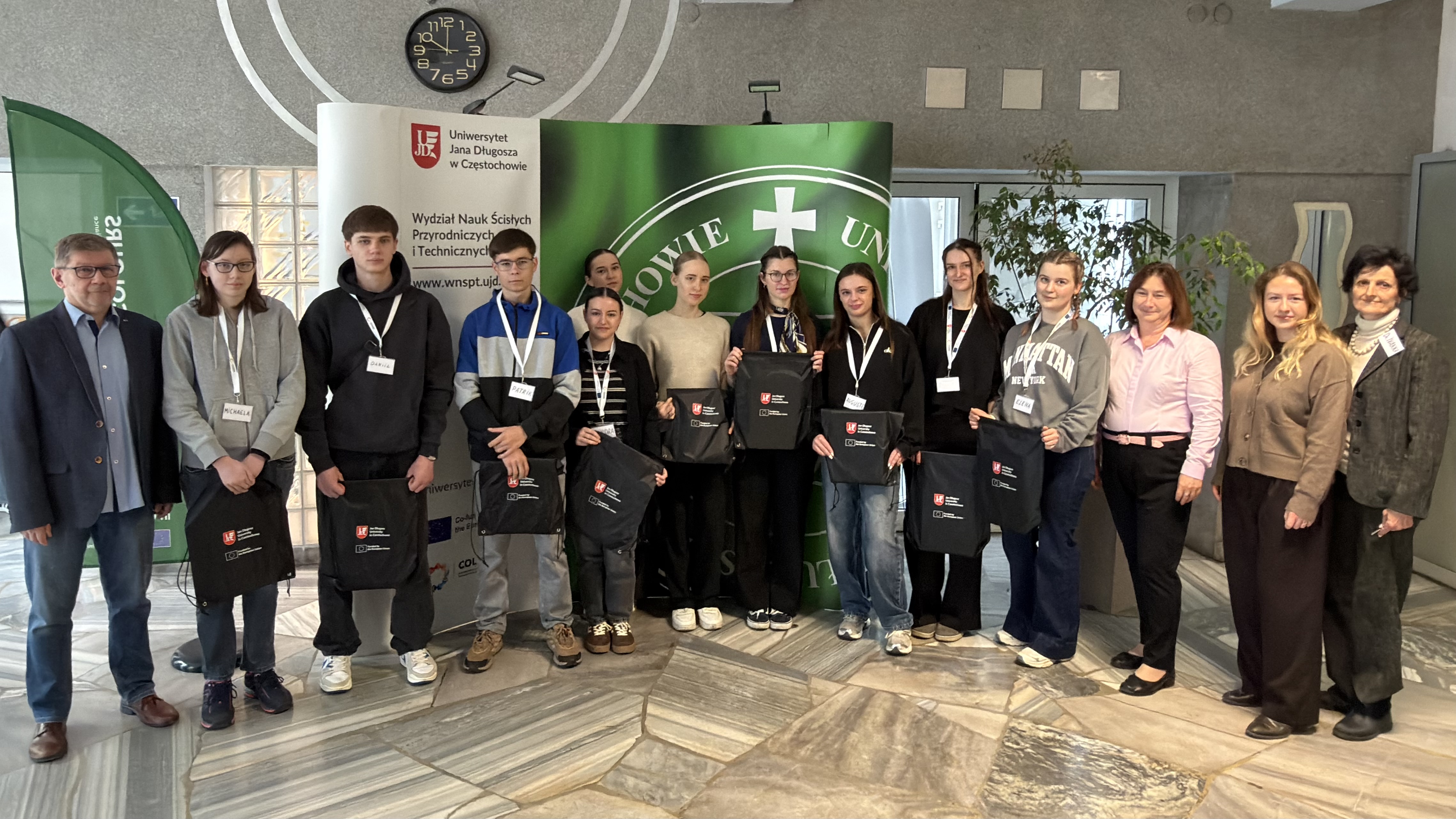 Pamiątkowe zdjęcie uczestnik&oacute;w oraz kadry akademickiej programu BIP w holu Wydziału Nauk Ścisłych, Przyrodniczych i Technicznych UJD.